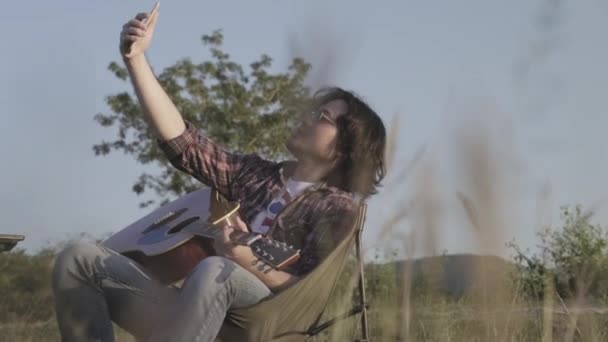 옆에서 기타를 노래를 부르는 잘생긴 곱슬머리 아시아 — 비디오