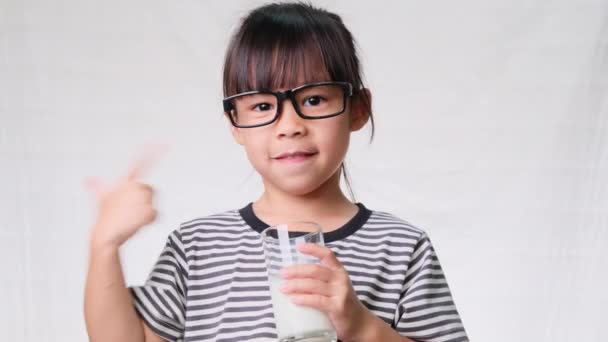 Leuk Klein Meisje Met Een Glas Melk Een Witte Achtergrond — Stockvideo