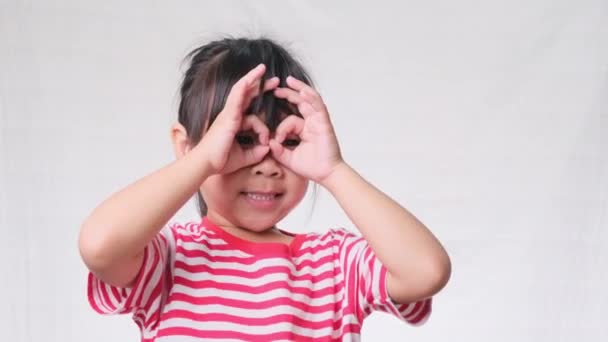 Милая Маленькая Девочка Делает Смешные Лица Очках Пальцев Форме Бинокля — стоковое видео
