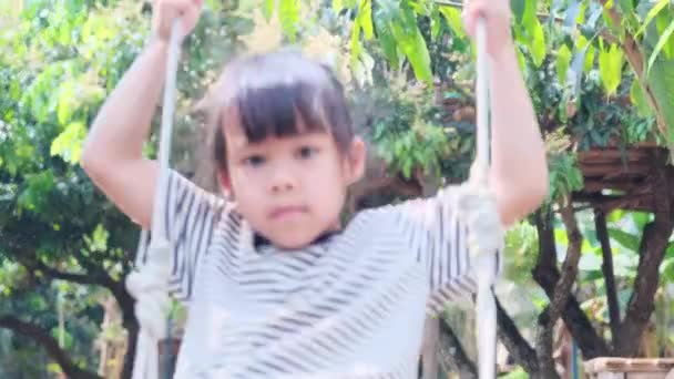 Gülümseyen Küçük Kız Yaz Bahçesinde Salıncakta Oynuyor — Stok video