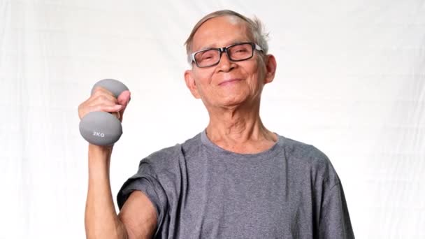 Yaşlı Asyalı Adam Dambılları Kaldırıyor Kol Kaslarını Gösteriyor Sağlıklı Yaşam — Stok video