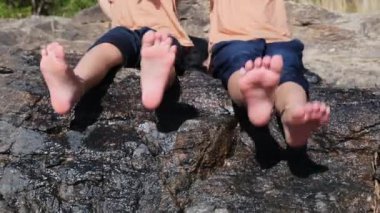 Orman deresinde kız kardeşiyle oynayan Asyalı küçük kız. Yazın nehirde çocuklarla aktif eğlence..