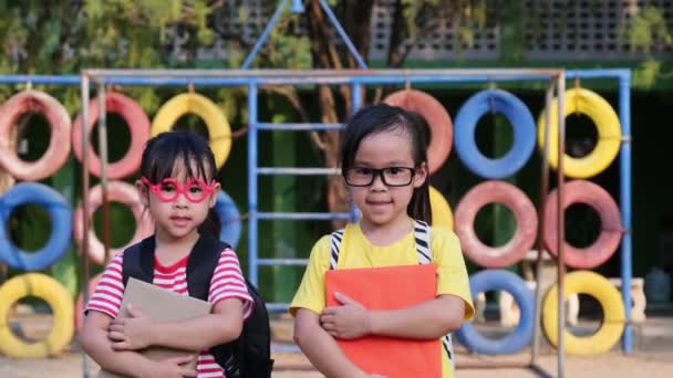 Dwie Słodkie Uczennice Ubrane Letnie Ubrania Plecakami Trzymając Książkę Uśmiechając — Wideo stockowe