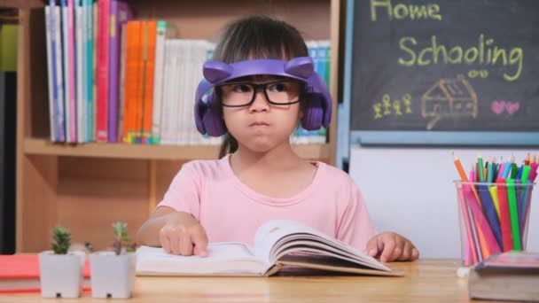 Linda Niña Con Auriculares Escuchando Audiolibros Mirando Libros Casa Aprender — Vídeo de stock