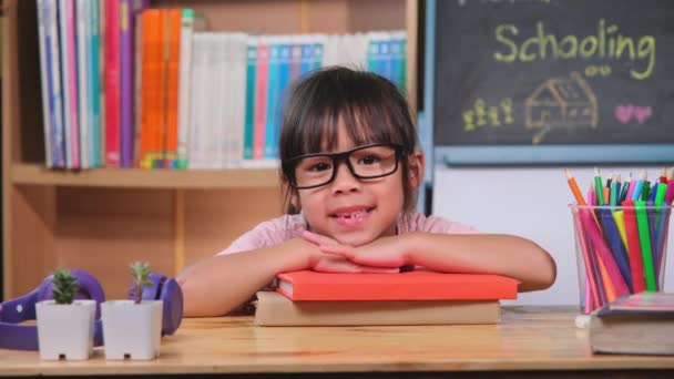 Linda Niña Sonríe Pone Barbilla Sobre Mano Montón Libros Casa — Vídeos de Stock