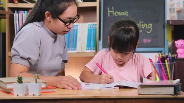 亚洲小女孩和她的母亲在隔离期间在家学习 妈妈在家里帮小女儿做作业 家庭教育 — 图库视频影像