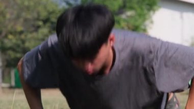 Otlakta şınav çeken sağlıklı genç bir adam. Sporda dinamik egzersiz ve kardiyo eğitimi kavramı.