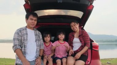 Mutlu aile yaz tatilinde araba yolculuğunun tadını çıkarıyor. Aile en sevdikleri arabayla yola çıkıyor. Tatil ve seyahat aile kavramı.