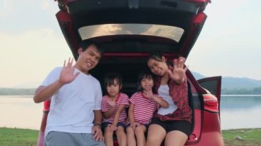 Mutlu aile yaz tatilinde araba yolculuğunun tadını çıkarıyor. Aile en sevdikleri arabayla yola çıkıyor. Tatil ve seyahat aile kavramı.