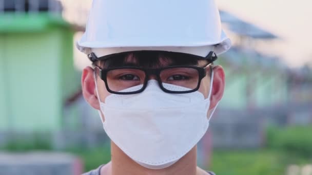 Joven Ingeniero Asiático Con Casco Máscara Mira Sonríe Cámara Fondo — Vídeo de stock