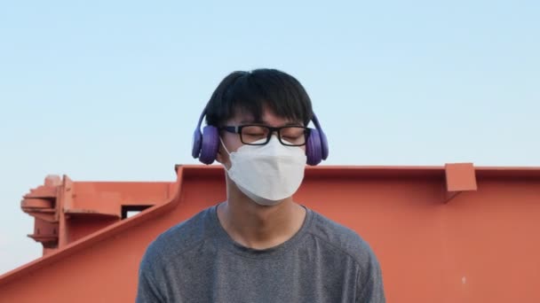 Feliz Joven Asiático Con Una Máscara Auriculares Escuchando Música Jardín — Vídeo de stock