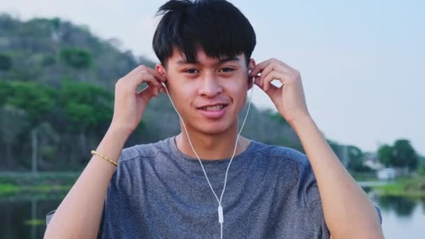 Happy Young Asian Man Wearing Earphone Listening Music Summer Garden — Stock Video