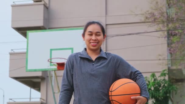 Azji Kobieta Gospodarstwa Koszykówki Patrząc Aparat Kciukami Góry Zewnątrz Koszykówki — Wideo stockowe