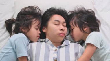Mutlu çocukların evdeki bir yatakta anneleriyle oynayıp kameraya baktıklarının en üst görüntüsü. Evde iyi vakit geçir..