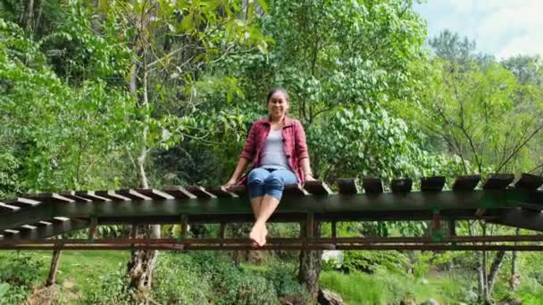 Una Bella Donna Asiatica Siede Ponte Legno Attraverso Ruscello Una — Video Stock