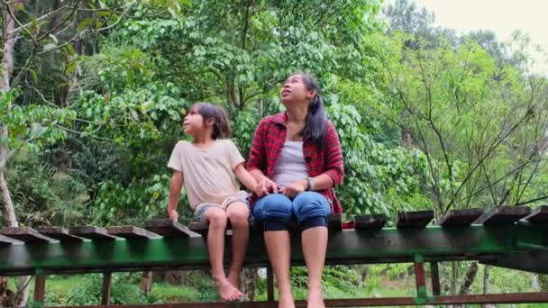 Щаслива Азіатська Мати Дочкою Сидять Дерев Яному Мосту Через Річку — стокове відео