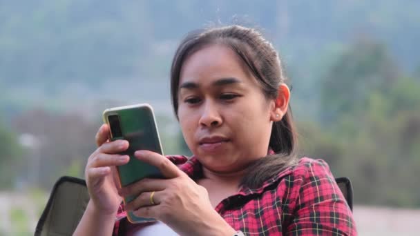 Bella Donna Asiatica Siede Una Sedia Campeggio Utilizza Uno Smartphone — Video Stock