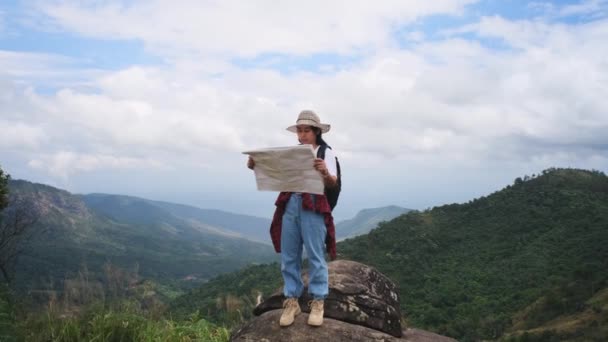 希斯特女人背着背包看了看山上的地图 女性徒步旅行者在大自然中休息并阅读地图 — 图库视频影像
