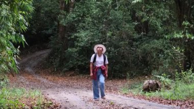 Sonbahar ormanlarında gezen sırt çantalı genç bir turist. Aktif sağlıklı yaşam tarzı.