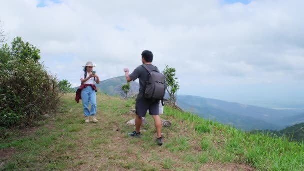 Kobieta Backpacker Pyta Drogę Męskiego Podróżnika Przechodzącego Przez Szczyt Góry — Wideo stockowe