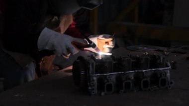 Kaynak maskesi ve eldiven giyen profesyonel adamlar kaynak ve argon ile ev atölyesinde çalışıyorlar..