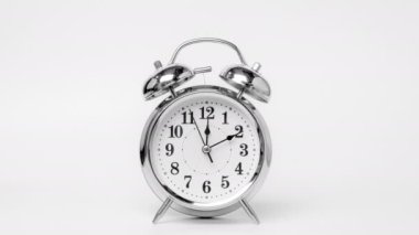 Time lapse of retro alarm clock running isolated on white background. Twelve o'clock on The New Years of the beautiful alarm clock face. Stop motion Animation of Alarm clock running.