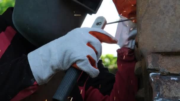 带着焊面和手套的熟练金属工人在家庭车间使用电弧焊机工作 用火花焊接金属的工人 — 图库视频影像