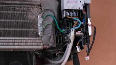 Kirli klima üfleme vantilatörünün iç bölümleri ve devre kartı, yakın plan. Erkek teknisyen içeride klimayı temizliyor. Evde bakım ve hijyen kavramları.