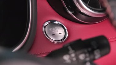The driver's hand is pressing the button to start the car engine. Keyless ignition start of the engine. Concept of transportation and technology