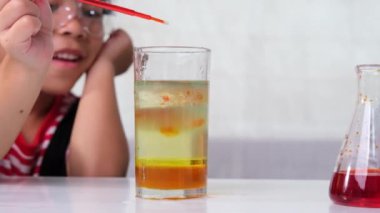 Çocuklar sınıfta öğreniyor ve fen deneyleri yapıyorlar. Evde eğitim için bilim deneyi yapan küçük bir kız. Evdeki çocuklar için kolay ve eğlenceli bilimsel deneyler..