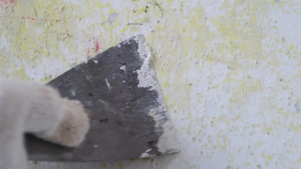 用金属铲把工人的手在水泥墙上的旧油漆刮掉 装修和粉刷家中的墙壁 准备粉刷房间 — 图库视频影像