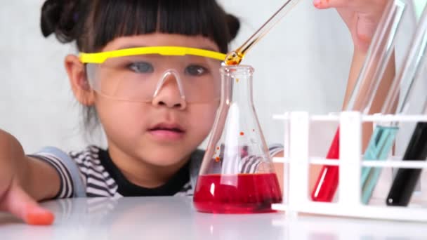 孩子们正在教室里学习和做科学实验 小女孩在玩家教科学实验 在家里给孩子们做简单有趣的科学实验 — 图库视频影像