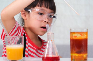 Çocuklar sınıfta öğreniyor ve fen deneyleri yapıyorlar. Evde eğitim için bilim deneyi yapan küçük bir kız. Evdeki çocuklar için kolay ve eğlenceli bilimsel deneyler..