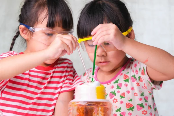 子どもたちは教室で科学実験を学び 行っています 家庭教育のための科学実験をしている2人の妹 自宅で子供たちのための簡単で楽しい科学実験 — ストック写真