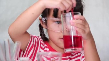 Çocuklar sınıfta öğreniyor ve fen deneyleri yapıyorlar. Evde eğitim için bilim deneyi yapan küçük bir kız. Evdeki çocuklar için kolay ve eğlenceli bilimsel deneyler..