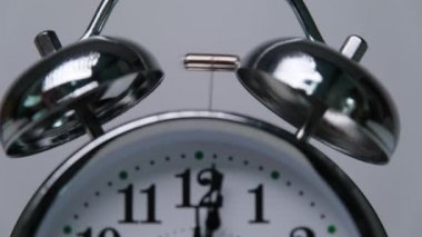 Beyaz arka planda izole edilmiş klasik çalar saatin yakın çekimi. Saat 12 hatırlatması. Zaman kavramı