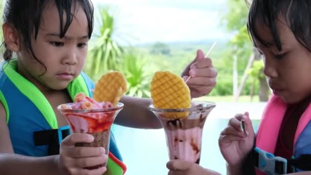 悲しい妹はプールでチョコレートアイスクリームのために戦う アジアの兄弟姉妹はアイスクリームのために口論する 家族の兄弟間の困難な関係 — ストック動画
