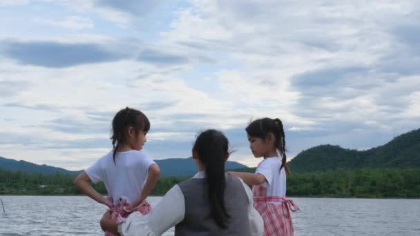 Feliz Madre Abrazando Sus Monas Hermanitas Disfrutando Naturaleza Junto Lago — Vídeo de stock