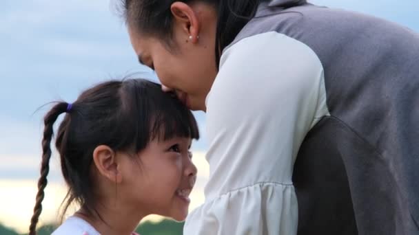 Любящая Мать Целует Милую Улыбающуюся Маленькую Девочку Обнимает Озера Счастливая — стоковое видео