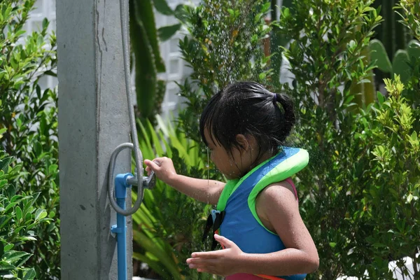 屋外シャワーでフリック水着でかわいい女の子 幸せな女の子は夏の日に楽しんで水で遊んで — ストック写真