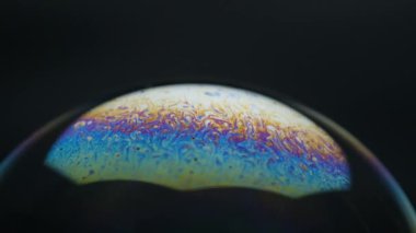 Sabun köpükleri siyah arkaplanda izole edilmiş. Renkli yansımalı soyut sabun köpükleri. Hareket arkaplanında sabun köpükleri.