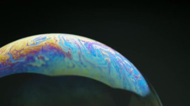 Sabun köpükleri siyah arkaplanda izole edilmiş. Renkli yansımalı soyut sabun köpükleri. Hareket arkaplanında sabun köpükleri.