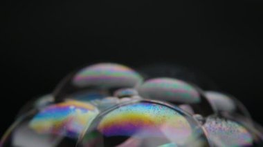 Soap bubbles isolated on black background. Abstract soap bubbles with colorful reflections. Soap bubbles in motion background.