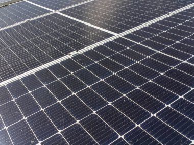Close-up of blue photovoltaic solar panels mounted on building roof. The concept of sustainable resources and renewable energy.