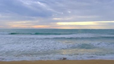 Beautiful sea waves and white sand beach in the tropical island. Beautiful view of the sunsets over sea. Ocean beach sunrise and dramatic colorful sky clouds