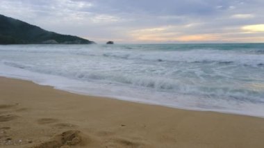 Beautiful sea waves and white sand beach in the tropical island. Beautiful view of the sunsets over sea. Ocean beach sunrise and dramatic colorful sky clouds