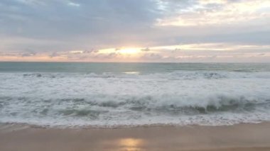 Beautiful sea waves and white sand beach in the tropical island. Beautiful view of the sunsets over sea. Ocean beach sunrise and dramatic colorful sky clouds