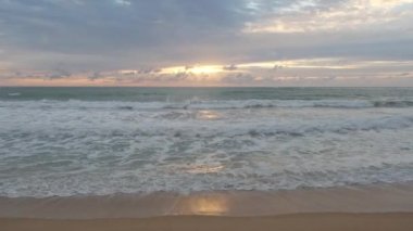 Beautiful sea waves and white sand beach in the tropical island. Beautiful view of the sunsets over sea. Ocean beach sunrise and dramatic colorful sky clouds