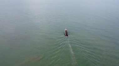 Aerial view from a drone of Thai traditional longtail fishing boats sailing in the sea. Top view of a fishing boat in the ocean.