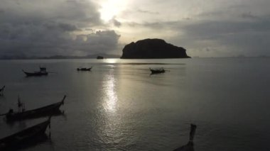 Aerial view from drones of fishing boats in the shore during low tide. Top view of many Thai traditional longtail fishing boats in the tropical islands. A lot of long tail boat on sea